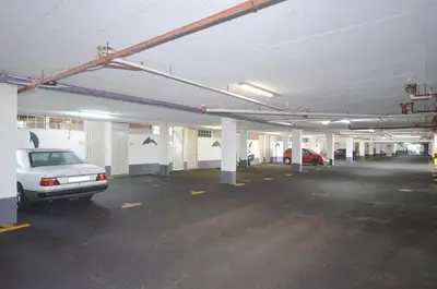 an empty parking garage with a car parked in it at Modern 2 Bedroom Apartment At Dolphin Beach in Cape Town