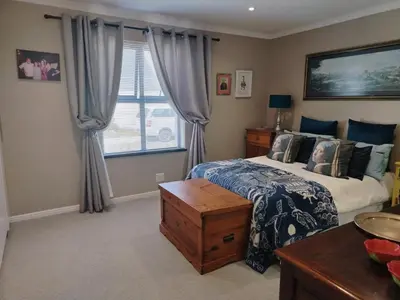 a bedroom with a bed and a window at Columbus Whales in Hermanus
