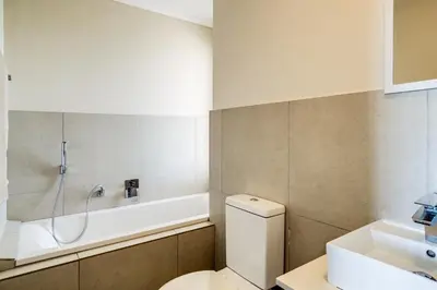 a bathroom with a toilet and a bath tub at Canalside Tranquility in Cape Town