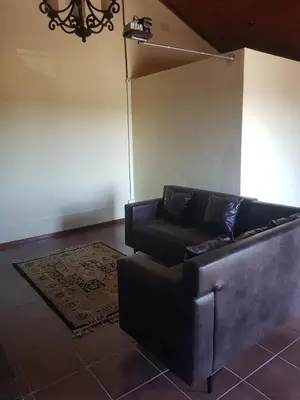 a living room with a couch and a chair at 4 th On Boundary in Gordonʼs Bay