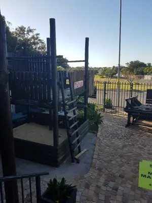 a park with two benches next to a fence at 4 th On Boundary in Gordonʼs Bay