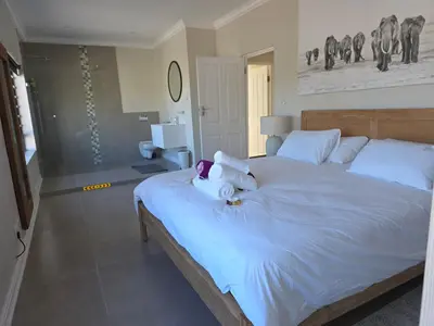 a bedroom with a large white bed with towels on it at Dolphin Paradise in Cape Town