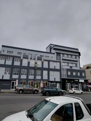 a white car parked in front of a large building at Granaat Pit - Paarl - Self Catering Apartment in Paarl