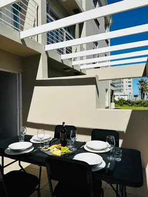 a black table with plates and wine glasses on it at Seaside Serenity in Cape Town