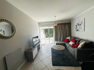 a living room with a couch and a mirror at Seaside Serenity in Cape Town
