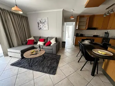 a living room with a couch and a table at Seaside Serenity in Cape Town