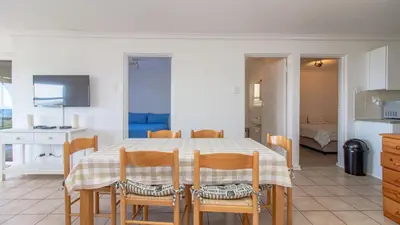 a kitchen and dining room with a table and chairs at 258 Hermanus Beach club in Hermanus