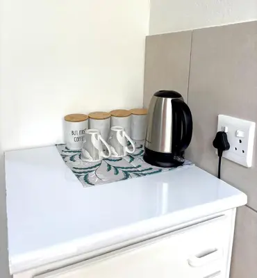 a counter top with a coffee pot and cups on it at Private Flatlet B in Goodwood