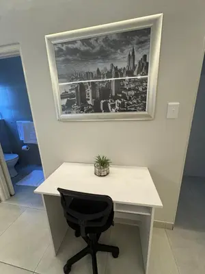 a desk with a black chair and a picture on the wall at Ocean Whisper Room 6 minutes away from the beach in Cape Town