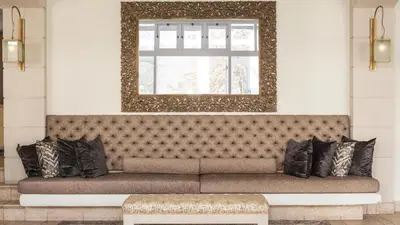 a couch in a room with a mirror and a window at Le Franschhoek Hotel & Spa by Dream Resorts in Franschhoek