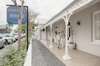 a group of people walking down a sidewalk at Dorpshuis Apartment, Main Street, Paarl in Paarl