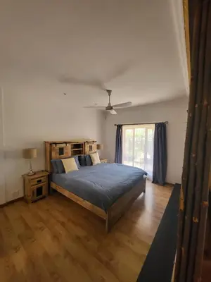 a bedroom with a large bed and a window at Apricot Gardens Guesthouse in Gordonʼs Bay