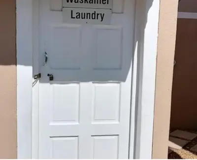 a white door with a sign on top of it at 46 Atlanta - A Home away from Home in Strand