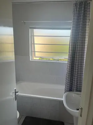 a bathroom with a tub and a sink and a window at 46 Atlanta - A Home away from Home in Strand