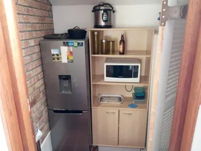 a small kitchen with a refrigerator and a microwave at Spacious Self-Catering Apartment with Private Entrance in Peaceful Paradyskloof, Stellenbosch in Stellenbosch
