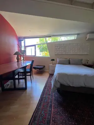 a bedroom with a bed and a desk and a table at Spacious Self-Catering Apartment with Private Entrance in Peaceful Paradyskloof, Stellenbosch in Stellenbosch