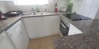a kitchen with a sink and a stove at Unit 169 Hermanus Beach Club in Hermanus