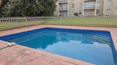 a swimming pool in front of a building at Unit 169 Hermanus Beach Club in Hermanus