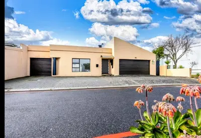 a house with a driveway in front of it at Greens Golf Course Apartment in De Grendel