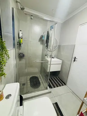 a bathroom with a shower with a toilet and a sink at Tranquil Luxe Retreat in Cape Town