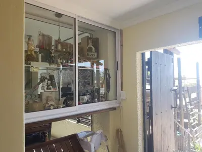 a glass cabinet in a room with a window at 4th On Boundary in Gordonʼs Bay