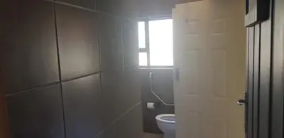 a bathroom with a toilet and a window at 4th On Boundary in Gordonʼs Bay
