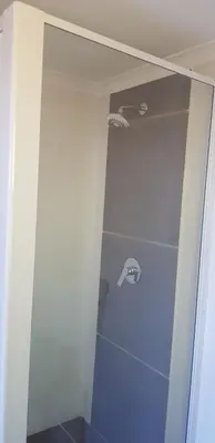 a bathroom with a shower with a glass door at 4th On Boundary in Gordonʼs Bay