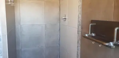 a shower with a glass door in a bathroom at 4th On Boundary in Gordonʼs Bay