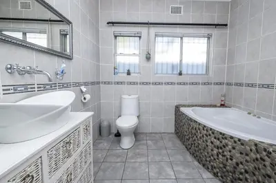 a bathroom with a tub and a toilet and a sink at Ridah's Accomodation in Bellville