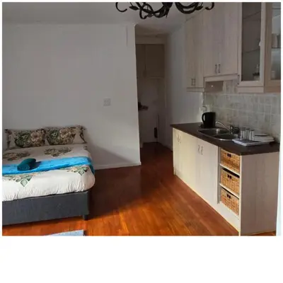 a kitchen with a bed and a sink in a room at Ridah's Accomodation in Bellville