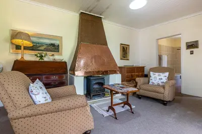 a living room with two chairs and a fireplace at Natte Valleij in Klapmuts