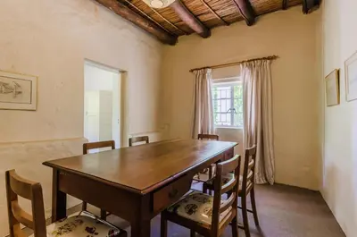 a dining room with a wooden table and chairs at Natte Valleij in Klapmuts