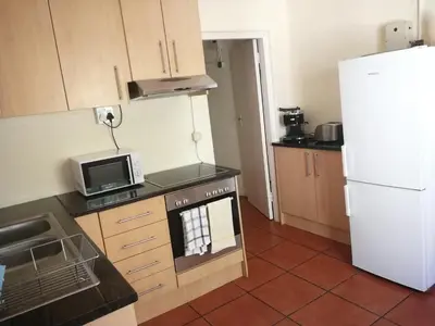 a kitchen with a stove and a white refrigerator at Natte Valleij in Klapmuts