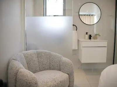 a living room with a chair and a mirror at Cherrywood Guest House in Cape Town