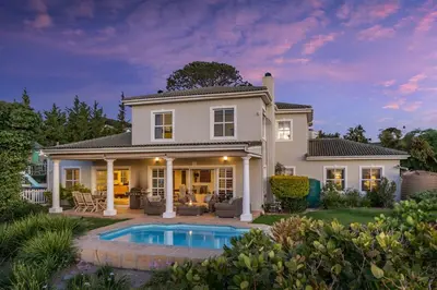 a house with a swimming pool in the yard at Cheerful 4 bedroom home with pool & wonderful view in Somerset West