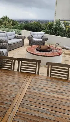 a patio with two benches and a fire pit at Cheerful 4 bedroom home with pool & wonderful view in Somerset West