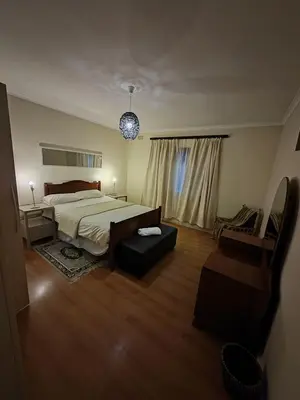 a large bedroom with a bed and a chair at The Palm's on Pastorie in Pniel