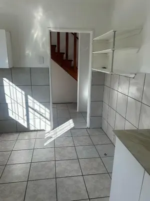 a kitchen with a staircase and a tiled floor at p22 voevlei in Victory Hill