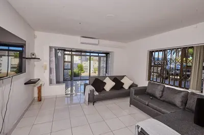 a living room with two couches and a couch at Townhouse in Bloubergstrand in Cape Town