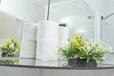 a bunch of towels on a glass table in a bathroom at Townhouse in Bloubergstrand in Cape Town