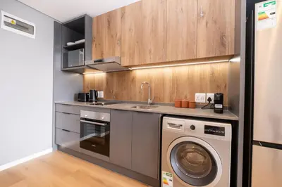 a kitchen with a sink and a washing machine at 510 Riverlands - Lux 1 bedroom Apartment in Cape Town