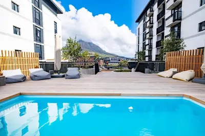 a swimming pool in the middle of a courtyard with buildings at 510 Riverlands - Lux 1 bedroom Apartment in Cape Town