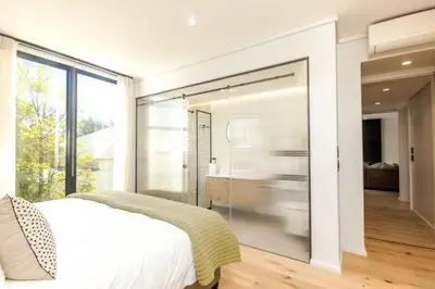 a bedroom with a large glass wall at Stylish Apartment in Cape Winelands District in Stellenbosch