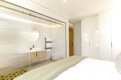 a bedroom with a large bed and a sink at Stylish Apartment in Cape Winelands District in Stellenbosch
