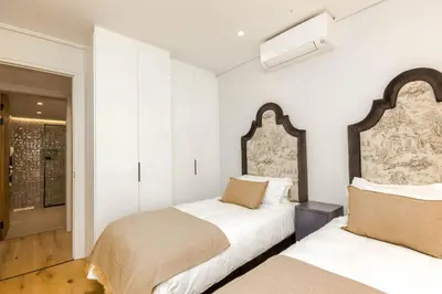 two beds in a room with white walls at Stylish Apartment in Cape Winelands District in Stellenbosch
