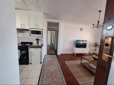 a kitchen with white cabinets and a stove top oven at Villa d'aqua in Cape Town