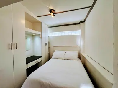 a small bedroom with a bed and a window at White Pearl at Strand in Strand