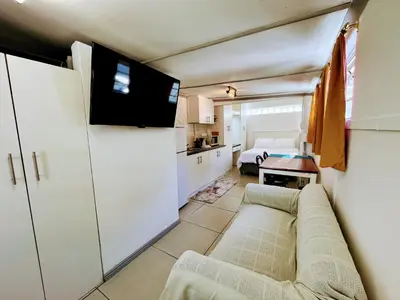 a living room with a couch and a bedroom at White Pearl at Strand in Strand