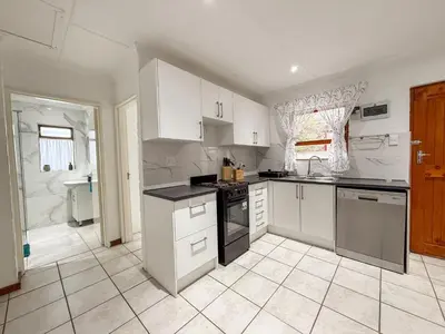 a kitchen with white cabinets and a sink at Gulls Nest in Hermanus