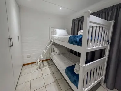 a bedroom with two bunk beds in a room at Gulls Nest in Hermanus